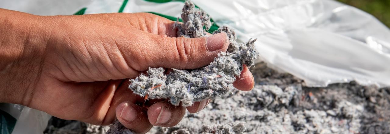 hand picking up cellulose insulation
