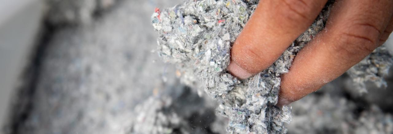 person reaching in bag of cellulose insulation
