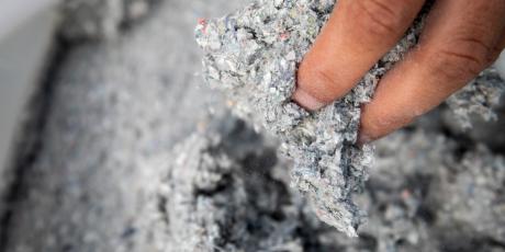person reaching in bag of cellulose insulation